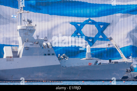 Eilat. A 'Saar 5' missile frigate anchored along a large Israeli flag painted on a hangar in a military port. Stock Photo