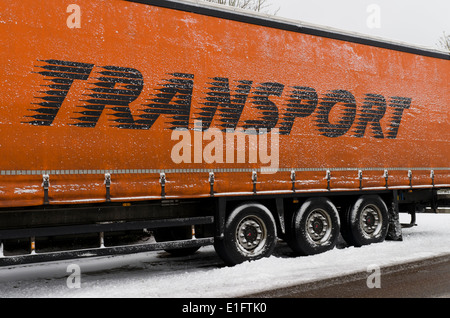 Semitrailer truck driving on winter blizzard asphalt road. Top view ...