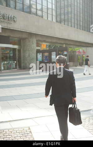 Tokyo Japan - Businessman wearing black suit and holding suitcase Stock Photo