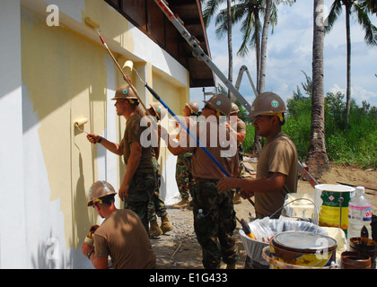 U.S. Navy Sailors attached to Naval Mobile Construction Battalion 11 paint a school during an engineering civic action project Stock Photo