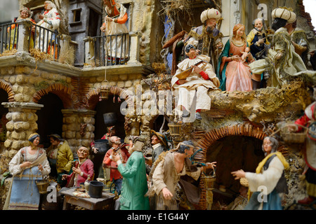 Whimsical creche scene of people in Bethlehem village including holy family and Magi Stock Photo