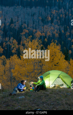 A man and a woman camping at night near yellow aspens, Durango, Colorado. Stock Photo