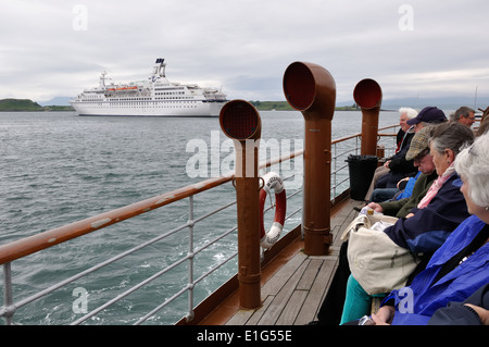 Passengers on board the Waverley paddle steamer approach the Astor cruise liner in Oban bay, Scotland Stock Photo