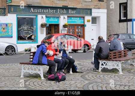 People eating fish and chips bought from the award winning Anstruther fish bar Stock Photo