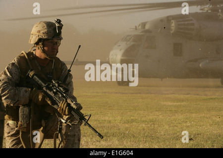 A U.S. Marine provides security for a CH-53 Super Stallion helicopter during noncombatant evacuation and repatriation training Stock Photo