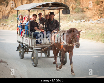 A Flower Hmong family rides in a horse-drawn cart just outside of Bac Ha, Lao Cai Province, Vietnam. Stock Photo