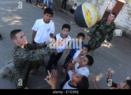 U.S. Marine Corps Cpl. Robert Wrobleski, left, and U.S. Navy Builder 2nd Class Joshua Helton play basketball with students at E Stock Photo