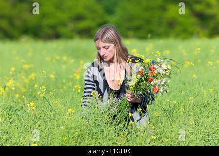 Woman Picking Wild Flowers on the Meadow in Spring Stock Photo