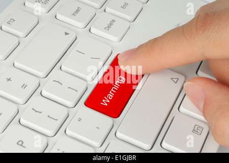 Hand pushing red warning button on the keyboard Stock Photo