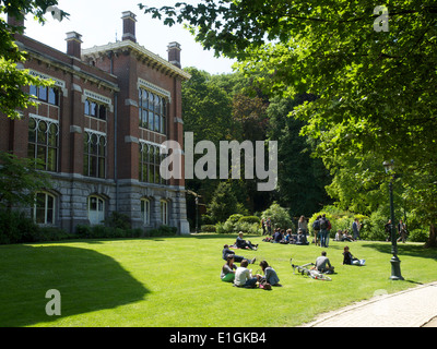 People relaxing on a lawn in the Leopold park in the European district of Brussels, Belgium Stock Photo