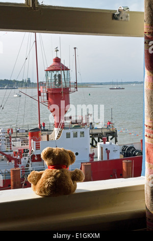 Lightship LV18 moored at Harwich Ha'penny Pier, Essex, seen by small teddy bear from a window in the Pier Hotel Stock Photo