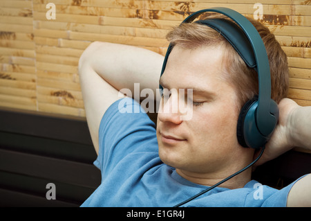 This is a photograph of laying young man listening music Stock Photo