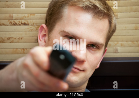 Young guy looking at camera while switching TV channels Stock Photo