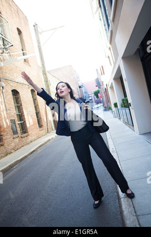 Businesswoman hailing taxi cab Stock Photo