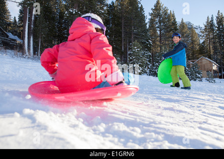 Siblings skiing on snow ground Stock Photo