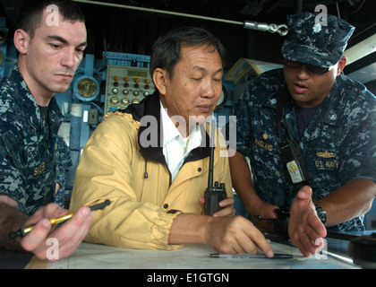 Singaporean harbor pilot Yap Chee Wah, center, U.S. Navy Cmdr. Adrian Ragland, right, the commanding officer of the dock landin Stock Photo