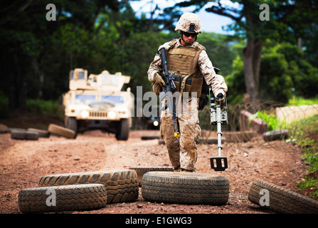 Lance Cpl. David Engel, an anti-tank missileman with Weapons Company, 3rd Battalion, 3rd Marine Regiment, uses a mine detector Stock Photo