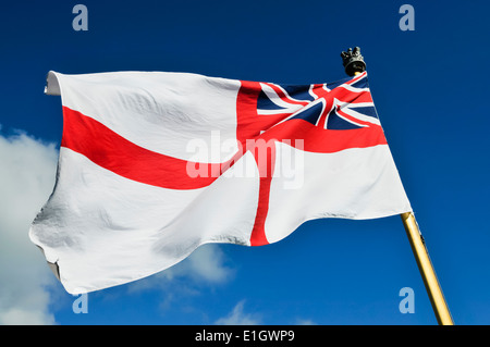 Royal Navy white ensign flying from a warship while docked. Stock Photo