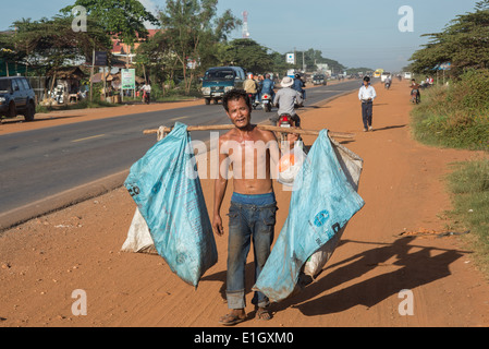 man collecting rubbish , People commute ,on bicycles on a dusty road ,in Cambodia ,truck, Stock Photo