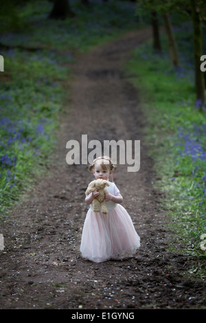 Little girl walking along a woodland path in Spring. Stock Photo