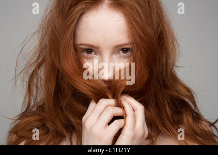 Portrait of young woman, hands in hair Stock Photo