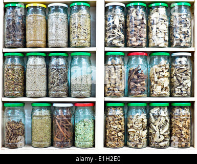 Assortment of glass jars on shelves in herbalist shop in marrakesh, morocco, containing herbs and spices for medicinal purposes Stock Photo