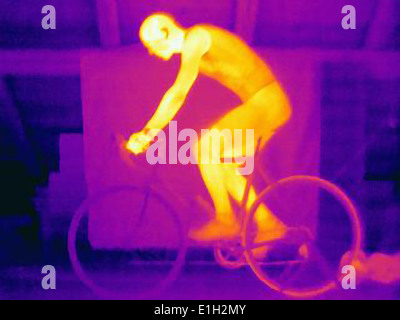 Side view thermal image of young male cyclist in training, showing the heat of the muscles and of the bicycle tires Stock Photo