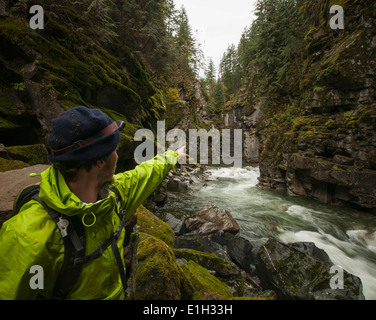Hiker points cliffs, Coquihalla Canyon provincial Park and Othello Tunnels, Trans-Canada Trail, Hope, British Columbia, Canada Stock Photo