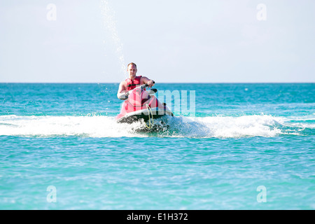 Young guy cruising on a jetski on the caribbean sea Stock Photo