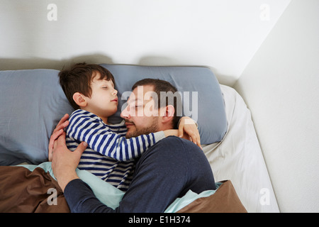 Father and son in bed Stock Photo