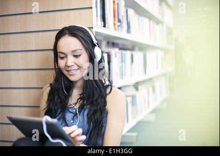 Young woman wearing headphones using digital tablet Stock Photo