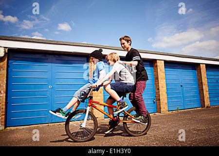 Boy giving two friends a ride on bike