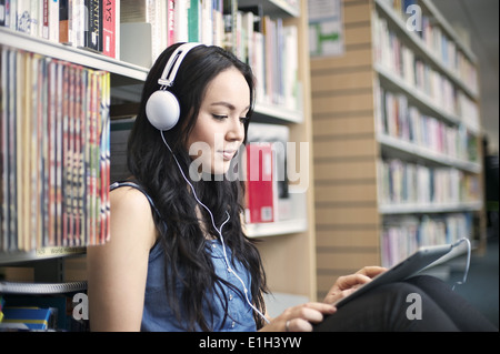 Young woman wearing headphones using digital tablet Stock Photo