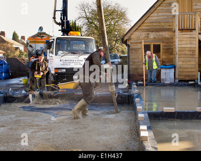 self building house, man pouring floor slab, directing concrete pump Stock Photo