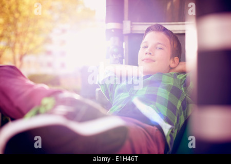 Portrait of boy relaxing with hands behind head Stock Photo