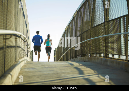 Man and woman running over bridge Stock Photo