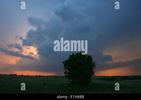 A low precipitation supercell peeks out above the setting sun on the horizon, Garden City, Kansas, USA Stock Photo