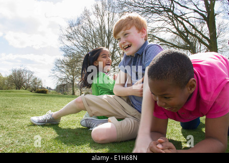 Two boys and a girl playing in field Stock Photo