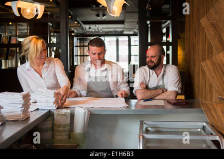 Chefs and waitress preparing for service in restaurant Stock Photo
