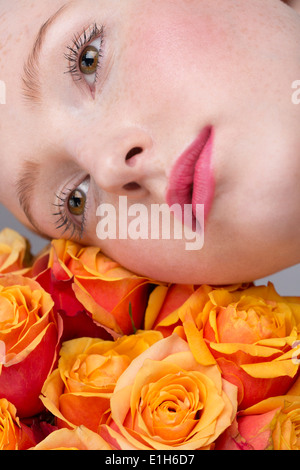 Portrait of young woman, holding bunch of roses Stock Photo