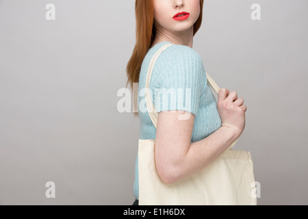 Cropped image of young woman carrying shopping bag