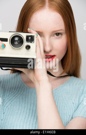 Young woman with polaroid camera Stock Photo