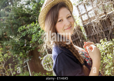 Portrait of teenage girl in straw hat in garden
