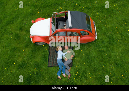 Overhead view of mature couple relaxing on picnic blanket Stock Photo