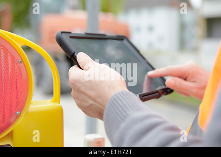 Foremans hands using digital tablet on road construction site Stock Photo