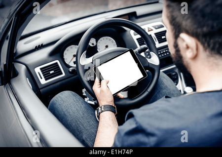 Man in the car, with the Tablet PC in hands Stock Photo