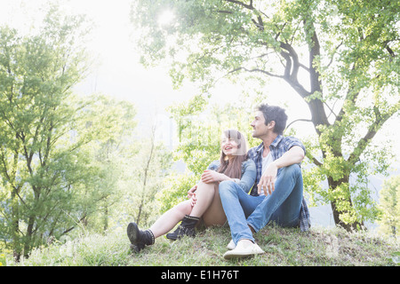 Young couple sitting on grass, Piemonte, Italy Stock Photo