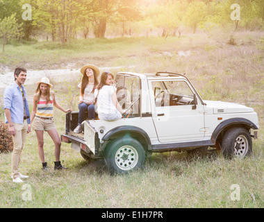Friends sitting on back of off road vehicle Stock Photo