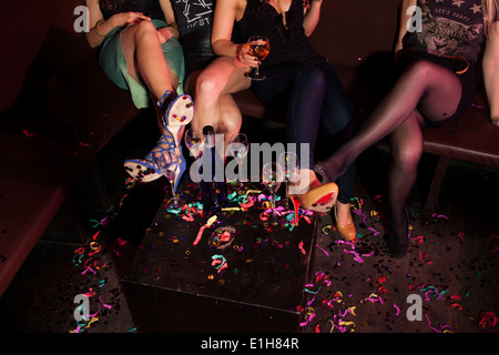 Cropped shot of female mini skirted friends in nightclub Stock Photo