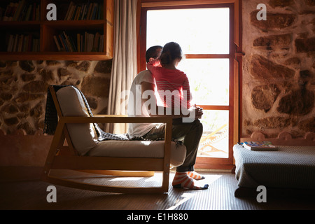 Mid adult man and daughter looking out of window